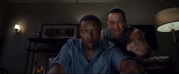 Movie still from “Don Jon” (2013), directed by Joseph Gordon-Levitt – A couple of men sitting next to each other in a room; Medium shot, High angle