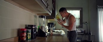 Movie still from “Don Jon” (2013), directed by Joseph Gordon-Levitt – A man in a kitchen looking at a tablet; Medium shot, Low angle