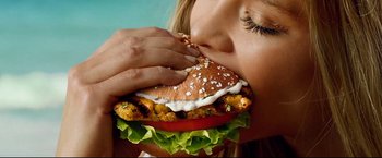 Movie still from “Don Jon” (2013), directed by Joseph Gordon-Levitt – A person biting into a hamburger; Extreme Close Up shot, Overhead angle