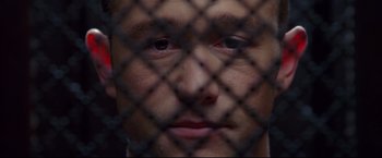 Movie still from “Don Jon” (2013), directed by Joseph Gordon-Levitt – A person behind a chain link fence; Extreme Close Up shot, Overhead angle