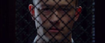 Movie still from “Don Jon” (2013), directed by Joseph Gordon-Levitt – A person behind a chain link fence; Close Up shot, Overhead angle
