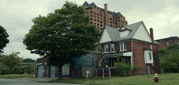 Movie still from “Don't Breathe” (2016), directed by Fede Alvarez – An image of an old building in a city setting; Extreme Wide shot, Low angle