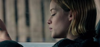 Movie still from “Don't Breathe” (2016), directed by Fede Alvarez – A young woman with closed eyes sitting in a car; Close Up shot, Low angle