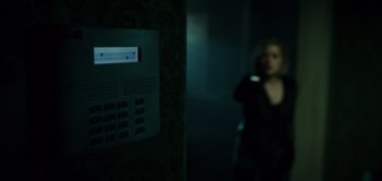 Movie still from “Don't Breathe” (2016), directed by Fede Alvarez – A woman standing in a dark room next to an alarm clock; Extreme Close Up shot, High angle