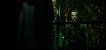 Movie still from “Don't Breathe” (2016), directed by Fede Alvarez – A man standing in front of a brick wall; Medium shot, Low angle