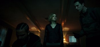 Movie still from “Don't Breathe” (2016), directed by Fede Alvarez – A woman standing in a dark room looking up; Medium shot, Low angle