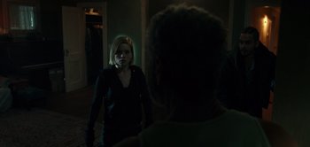 Movie still from “Don't Breathe” (2016), directed by Fede Alvarez – A woman standing next to a man in a dark room; Medium shot, Over the shoulder angle