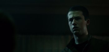 Movie still from “Don't Breathe” (2016), directed by Fede Alvarez – A young man in a dark room looking at the camera; Close Up shot, Low angle