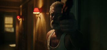 Movie still from “Don't Breathe” (2016), directed by Fede Alvarez – An old man with a beard is holding a gun; Medium shot, Over the shoulder angle