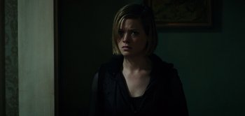 Movie still from “Don't Breathe” (2016), directed by Fede Alvarez – A woman with short blonde hair wearing a black jacket; Close Up shot, Over the shoulder angle