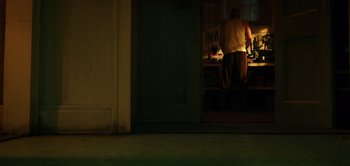 Movie still from “Don't Breathe” (2016), directed by Fede Alvarez – A man standing in front of an open door at night; Wide shot, High angle