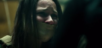 Movie still from “Don't Breathe” (2016), directed by Fede Alvarez – A woman with a taped up mouth and long hair; Close Up shot, Over the shoulder angle