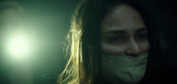 Movie still from “Don't Breathe” (2016), directed by Fede Alvarez – A woman with her mouth taped shut; Close Up shot, Low angle
