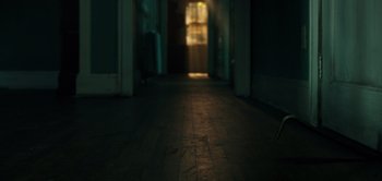 Movie still from “Don't Breathe” (2016), directed by Fede Alvarez – A dark hallway with a light shining on it; Wide shot, High angle