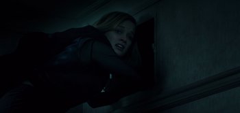 Movie still from “Don't Breathe” (2016), directed by Fede Alvarez – A woman is looking out of a window at night; Medium shot, Low angle