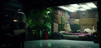 Movie still from “Don't Breathe” (2016), directed by Fede Alvarez – A living room filled with couches and a potted plant; Wide shot, High angle