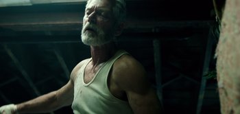 Movie still from “Don't Breathe” (2016), directed by Fede Alvarez – An old man with a beard and a white shirt; Close Up shot, Low angle