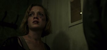 Movie still from “Don't Breathe” (2016), directed by Fede Alvarez – A young woman with a bruised face looking up; Close Up shot, Low angle