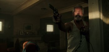 Movie still from “Don't Breathe” (2016), directed by Fede Alvarez – An older man holding a gun in a living room; Medium shot, Low angle