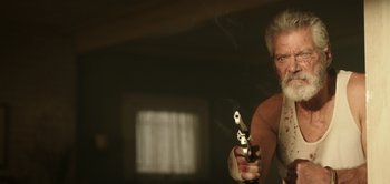 Movie still from “Don't Breathe” (2016), directed by Fede Alvarez – An older man holding a gun in a room; Close Up shot, Low angle