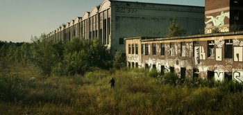 Movie still from “Don't Breathe” (2016), directed by Fede Alvarez – An abandoned building in the middle of a grassy field; Extreme Wide shot, High angle