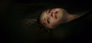 Movie still from “Don't Breathe” (2016), directed by Fede Alvarez – A woman with a bruised face laying on the ground; Close Up shot, Overhead angle
