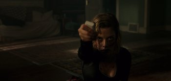 Movie still from “Don't Breathe” (2016), directed by Fede Alvarez – A woman is holding something in her hand; Medium shot, Low angle