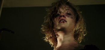 Movie still from “Don't Breathe” (2016), directed by Fede Alvarez – A woman with a knife in her mouth; Close Up shot, Low angle