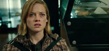 Movie still from “Don't Breathe” (2016), directed by Fede Alvarez – A woman with blonde hair and a plaid shirt looking at the camera; Close Up shot, Over the shoulder angle