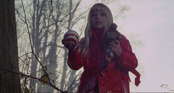 Movie still from “Don't Look Now” (1973), directed by Nicolas Roeg – A woman in a red coat holding a candy apple; Medium shot, Low angle