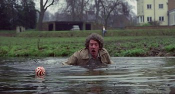 Movie still from “Don't Look Now” (1973), directed by Nicolas Roeg – A man in a trench coat is in a body of water; Wide shot, High angle