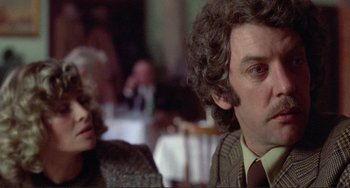 Movie still from “Don't Look Now” (1973), directed by Nicolas Roeg – A man and a woman sitting at a table in a restaurant; Close Up shot, Over the shoulder angle
