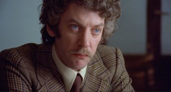 Movie still from “Don't Look Now” (1973), directed by Nicolas Roeg – A person wearing a suit and tie; Close Up shot, Low angle