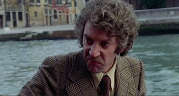 Movie still from “Don't Look Now” (1973), directed by Nicolas Roeg – A person wearing a suit and tie; Close Up shot, Over the shoulder angle