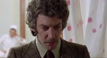 Movie still from “Don't Look Now” (1973), directed by Nicolas Roeg – A person wearing a suit and tie; Close Up shot, Low angle