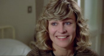 Movie still from “Don't Look Now” (1973), directed by Nicolas Roeg – A person with a smile on their face; Close Up shot, High angle