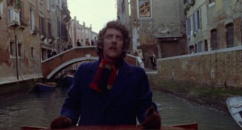 Movie still from “Don't Look Now” (1973), directed by Nicolas Roeg – A man in a blue jacket and a red scarf; Medium shot, Overhead angle