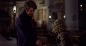 Movie still from “Don't Look Now” (1973), directed by Nicolas Roeg – A man and a woman standing next to each other in a church; Medium shot, Over the shoulder angle