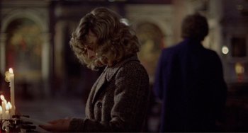 Movie still from “Don't Look Now” (1973), directed by Nicolas Roeg – A woman with blonde curly hair wearing a brown coat; Medium shot, Over the shoulder angle