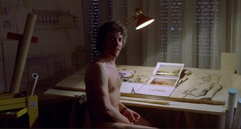 Movie still from “Don't Look Now” (1973), directed by Nicolas Roeg – A man sitting in front of a desk with a lamp; Medium shot, High angle