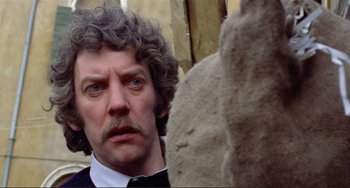 Movie still from “Don't Look Now” (1973), directed by Nicolas Roeg – A person wearing a suit and tie; Close Up shot, Low angle