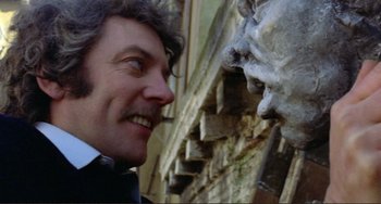 Movie still from “Don't Look Now” (1973), directed by Nicolas Roeg – A person near a statue of a man; Close Up shot, Low angle