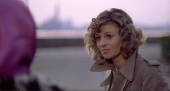 Movie still from “Don't Look Now” (1973), directed by Nicolas Roeg – A woman with curly blonde hair wearing a brown jacket; Close Up shot, Over the shoulder angle