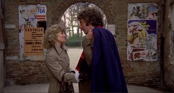Movie still from “Don't Look Now” (1973), directed by Nicolas Roeg – A man and a woman standing next to each other in front of an archway; Medium shot, Low angle