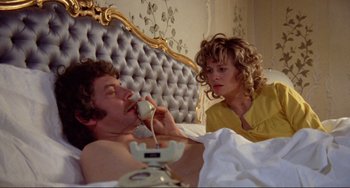 Movie still from “Don't Look Now” (1973), directed by Nicolas Roeg – A man and a woman in a bed with a phone; Medium shot, High angle