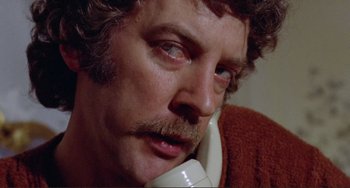 Movie still from “Don't Look Now” (1973), directed by Nicolas Roeg – A person talking on a phone; Close Up shot, Low angle