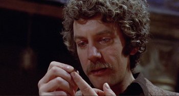 Movie still from “Don't Look Now” (1973), directed by Nicolas Roeg – A person holding something in his hand; Close Up shot, High angle