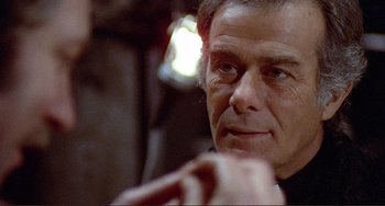 Movie still from “Don't Look Now” (1973), directed by Nicolas Roeg – A person with a beard looking at the camera; Close Up shot, Over the shoulder angle