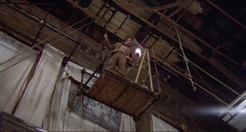Movie still from “Don't Look Now” (1973), directed by Nicolas Roeg – A man standing on top of a wooden platform; Wide shot, Low angle