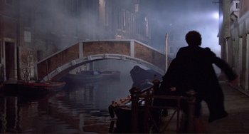 Movie still from “Don't Look Now” (1973), directed by Nicolas Roeg – A man is sitting on a boat in the water; Extreme Wide shot, High angle